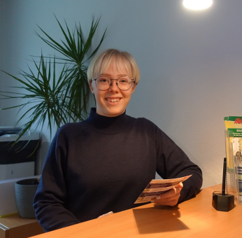 eine der auszubildenden von salvana mit informationsmaterial in der hand im buero, ausbildung bei salvana